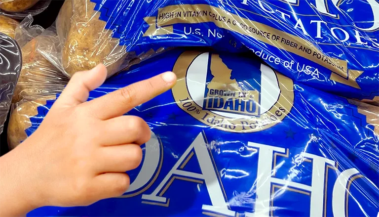 Finger pointing at IPC seal on bag of potatoes